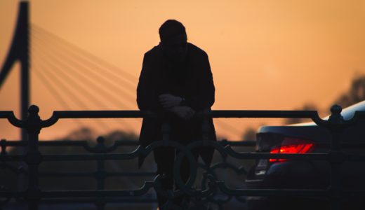 車の近くに腰掛ける男性